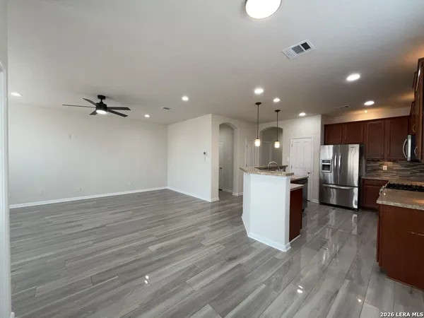 a view of kitchen with kitchen island wooden floor center island and stainless steel appliances