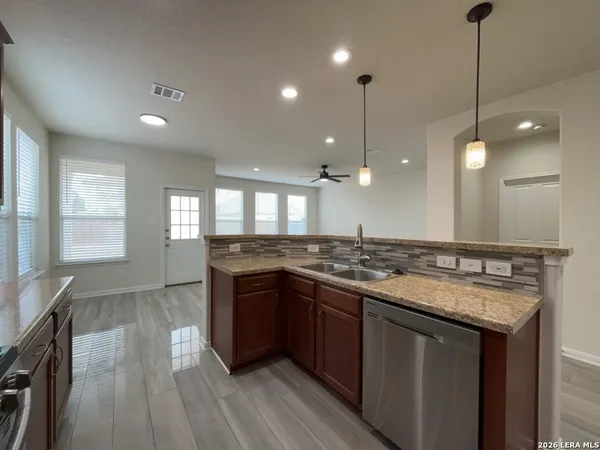 a kitchen with stainless steel appliances granite countertop a stove and a wooden floors