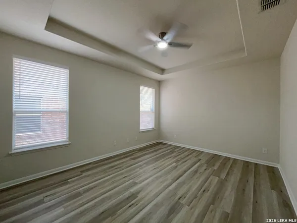 a view of an empty room with chandelier fan and a window