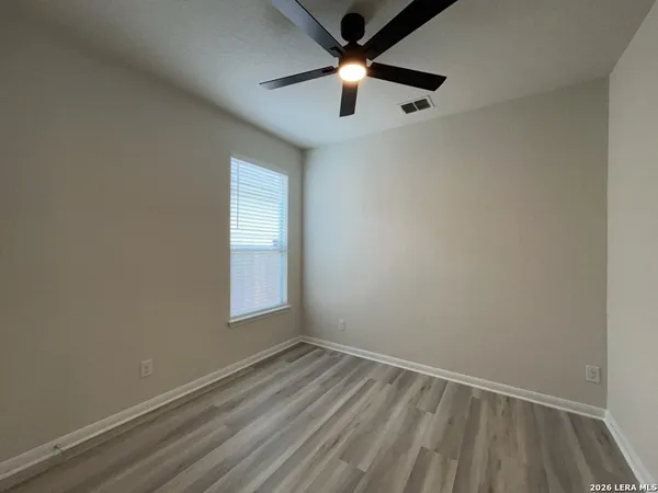 an empty room with a window and a fan