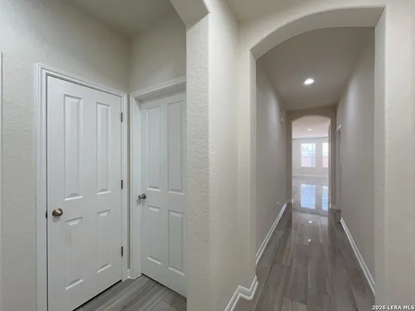 a view of a hallway with wooden floor and closet area