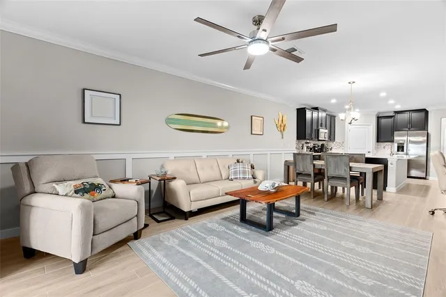 a living room with furniture a flat screen tv and a potted plant