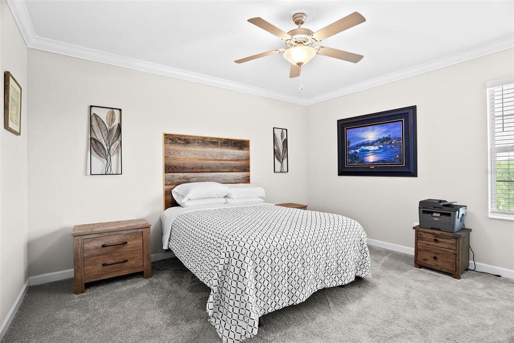 10232 Echo Dock Loop San Antonio, FL 33576 - Photo 20 of 43 a bedroom with a bed a lamp and a chandelier