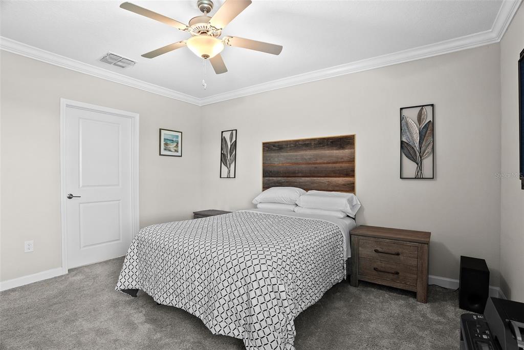 10232 Echo Dock Loop San Antonio, FL 33576 - Photo 21 of 43 a bedroom with a bed and a chandelier