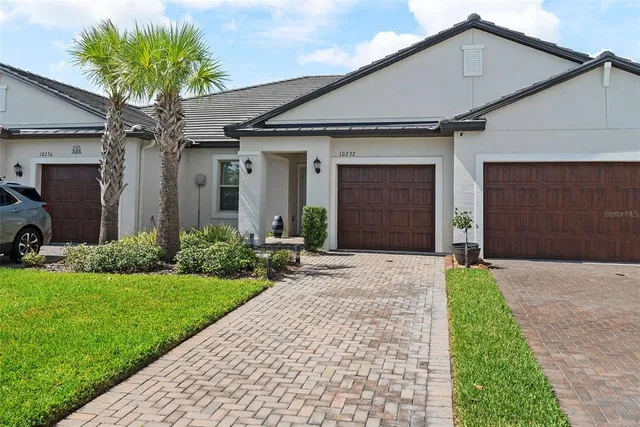 a front view of a house with a garden and garage