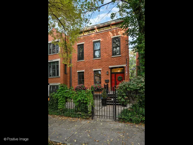 a view of a brick house with a yard and plants