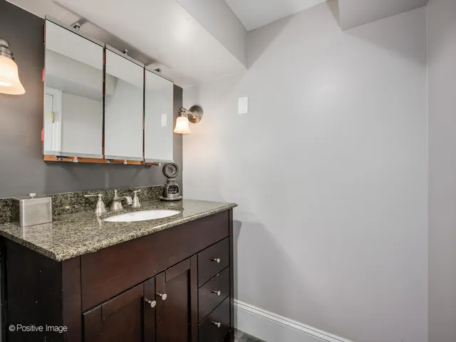 a bathroom with a granite countertop sink and a mirror