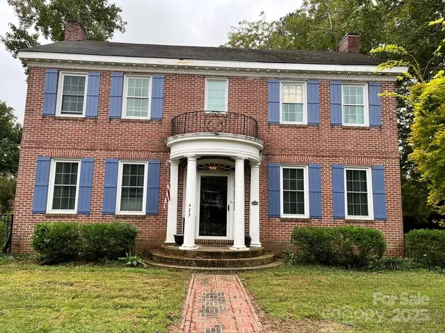 front view of a brick house with a yard