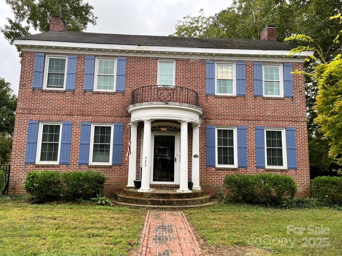 front view of a brick house with a yard