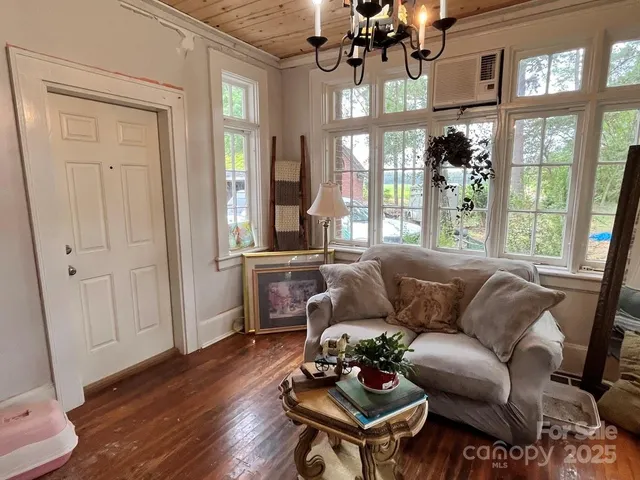 a living room with furniture a chandelier and a window