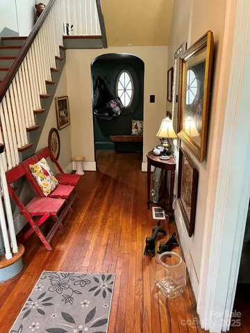 a view of a hallway with wooden floor windows wooden floor and a kitchen view