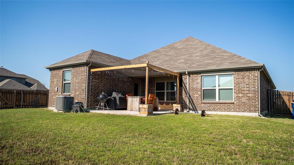 1837 Rialto Lane Crowley, TX 76036 - Photo 2 of 19 Expansive backyard featuring a covered patio with a wood pergola structure, a concrete patio, and a well-maintained lawn