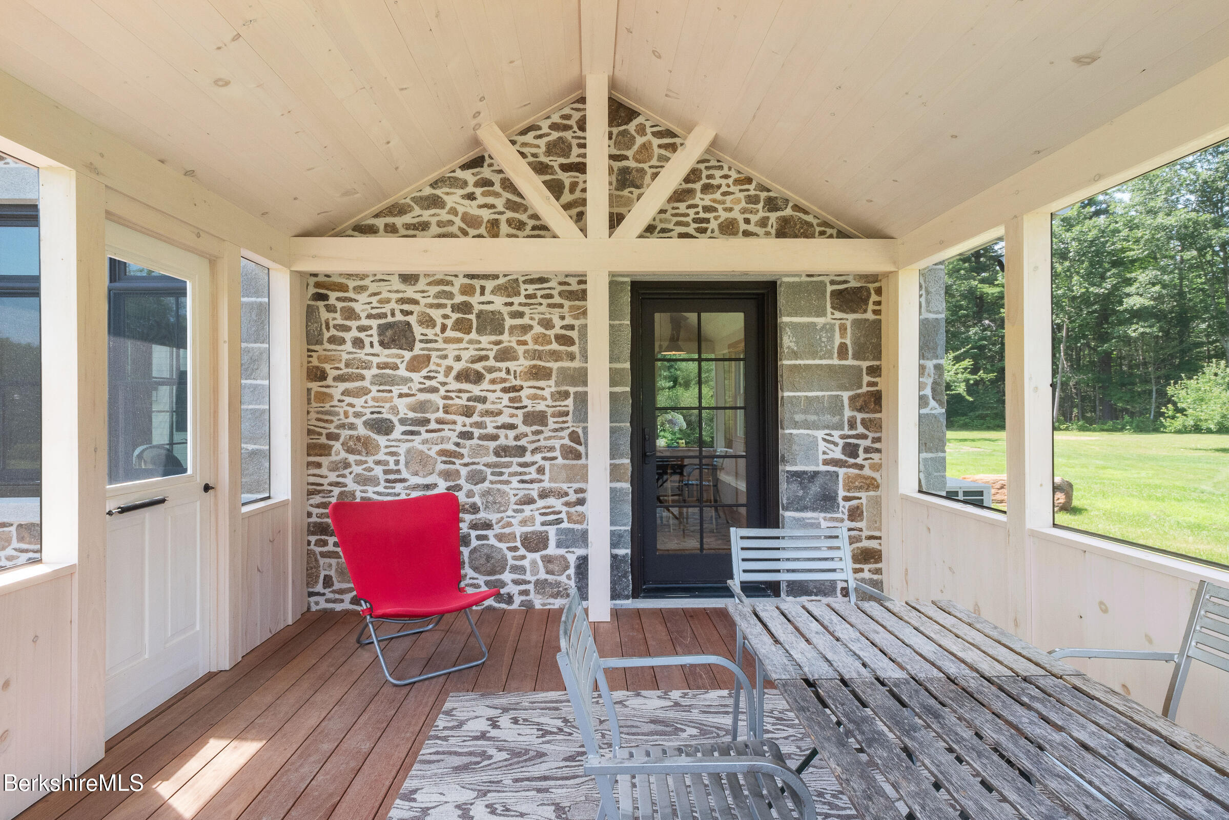 194 Sandisfield Road Sandisfield, MA 01255 - Photo 23 of 59 a view of a patio with a table and chairs next to a large window