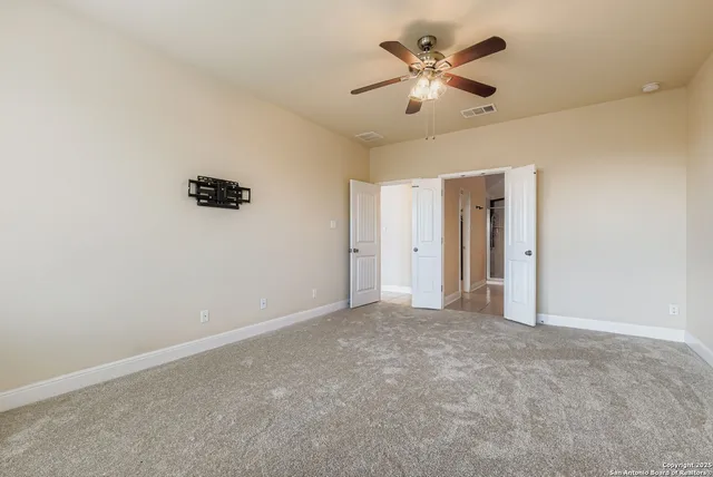 an empty room with closet and a chandelier fan
