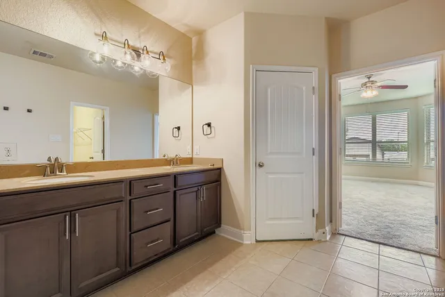 a bathroom with a granite countertop sink mirror and cabinets