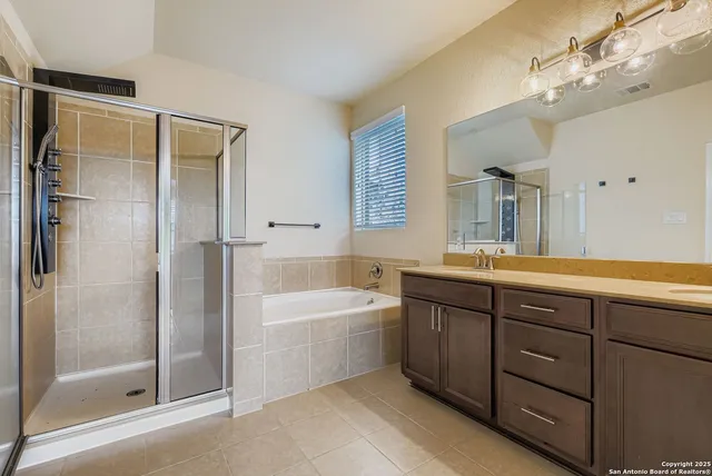 a spacious bathroom with a tub shower sink and mirror