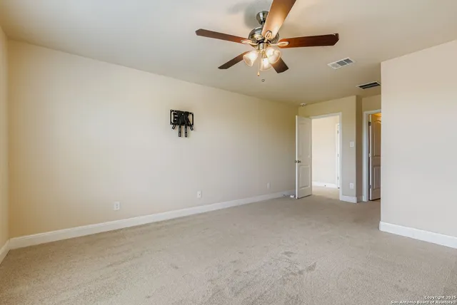an empty room with a ceiling fan and a window