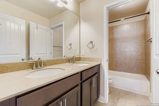a bathroom with a granite countertop sink mirror toilet and bathtub