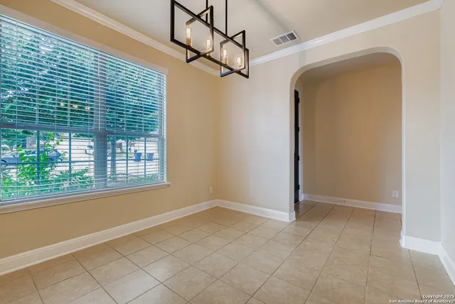a view of a livingroom with a chandelier fan and windows