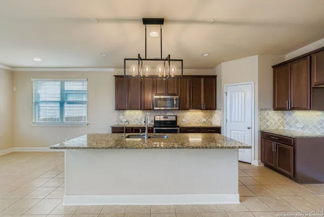 a large kitchen with granite countertop a stove and a sink