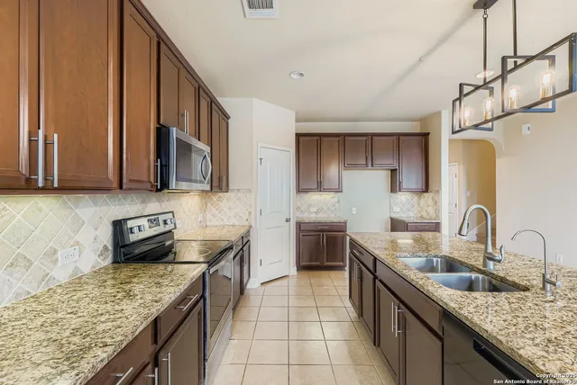 a kitchen with stainless steel appliances granite countertop a sink stove and refrigerator