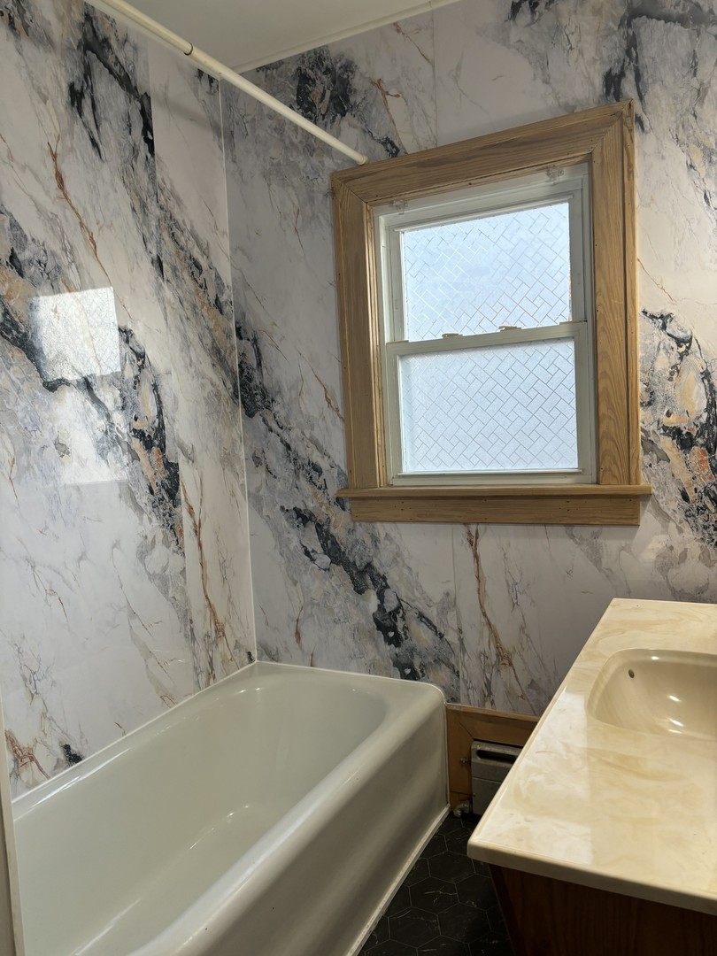 912 Clay Street Woodstock, IL 60098 - Photo 8 of 15 a bathroom with a bathtub and a shower