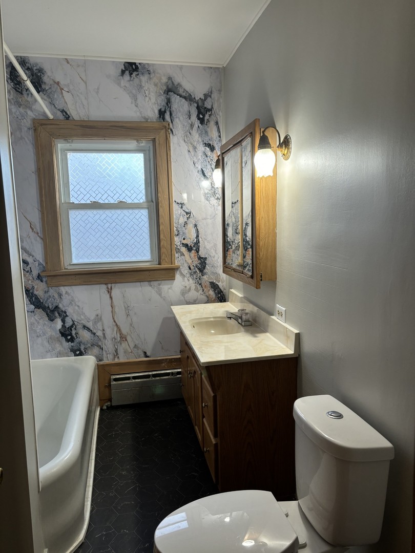 912 Clay Street Woodstock, IL 60098 - Photo 9 of 15 a bathroom with a sink toilet and mirror