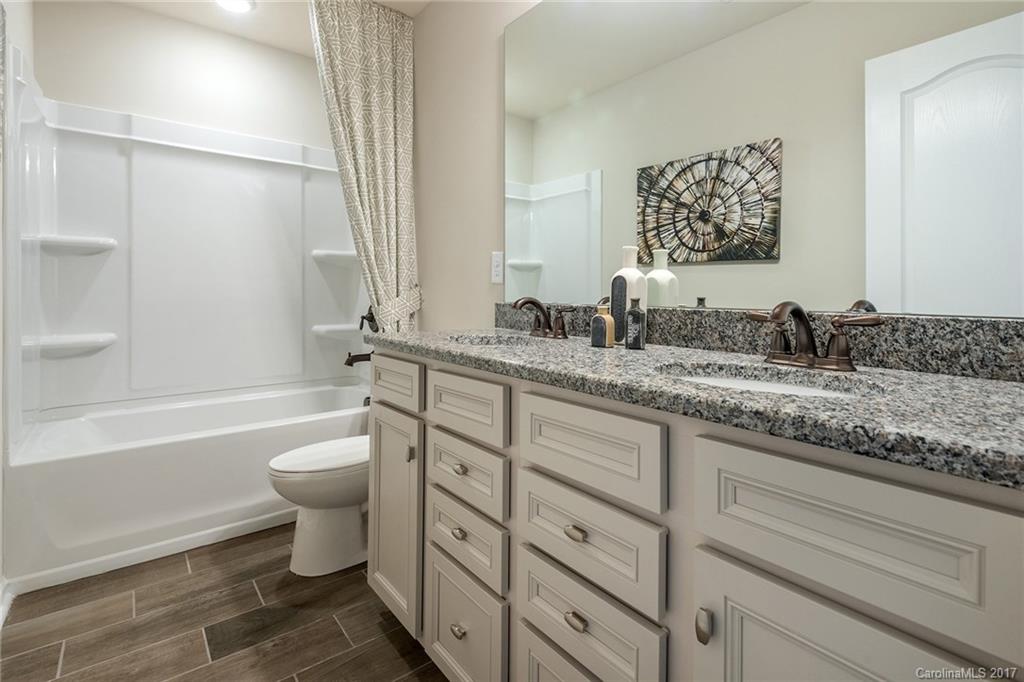 257 Keating Pl Drive, Unit 46 Fort Mill, SC 29708 - Photo 21 of 24 a bathroom with a granite countertop toilet sink and mirror
