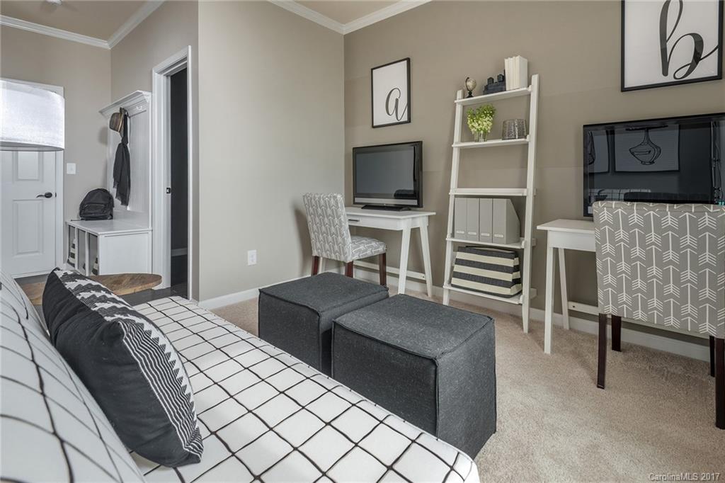 257 Keating Pl Drive, Unit 46 Fort Mill, SC 29708 - Photo 8 of 24 a bedroom with furniture a flat screen tv and a lamp