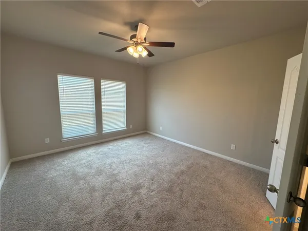 a view of an empty room with a chandelier fan