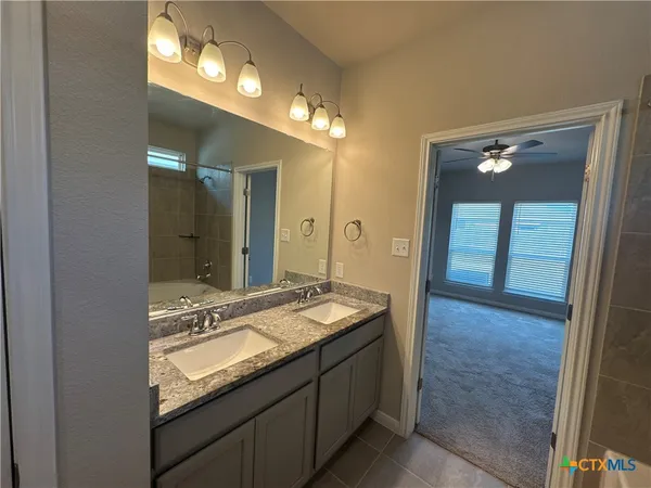 a bathroom with a granite countertop sink and a mirror