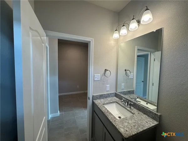a bathroom with a granite countertop sink a mirror and a shower