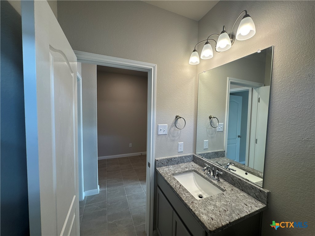 2214 Wasabi Road Temple, TX 76501 - Photo 5 of 26 a bathroom with a granite countertop sink a mirror and a shower