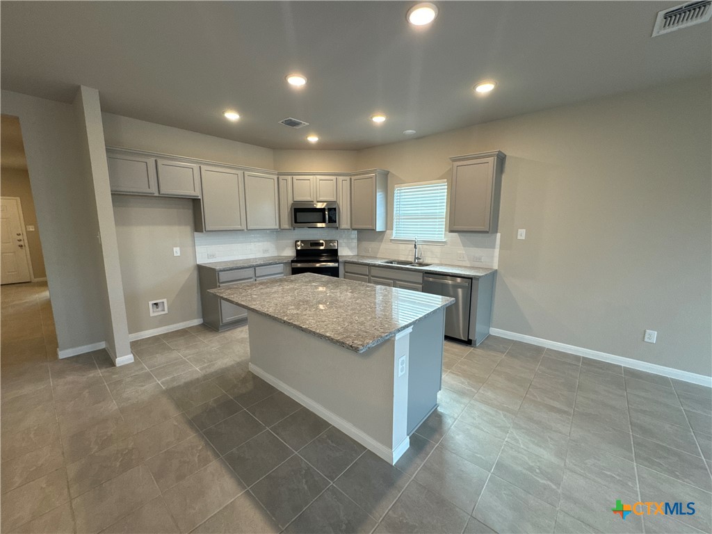 2214 Wasabi Road Temple, TX 76501 - Photo 7 of 26 a kitchen with stainless steel appliances granite countertop a sink stove and refrigerator