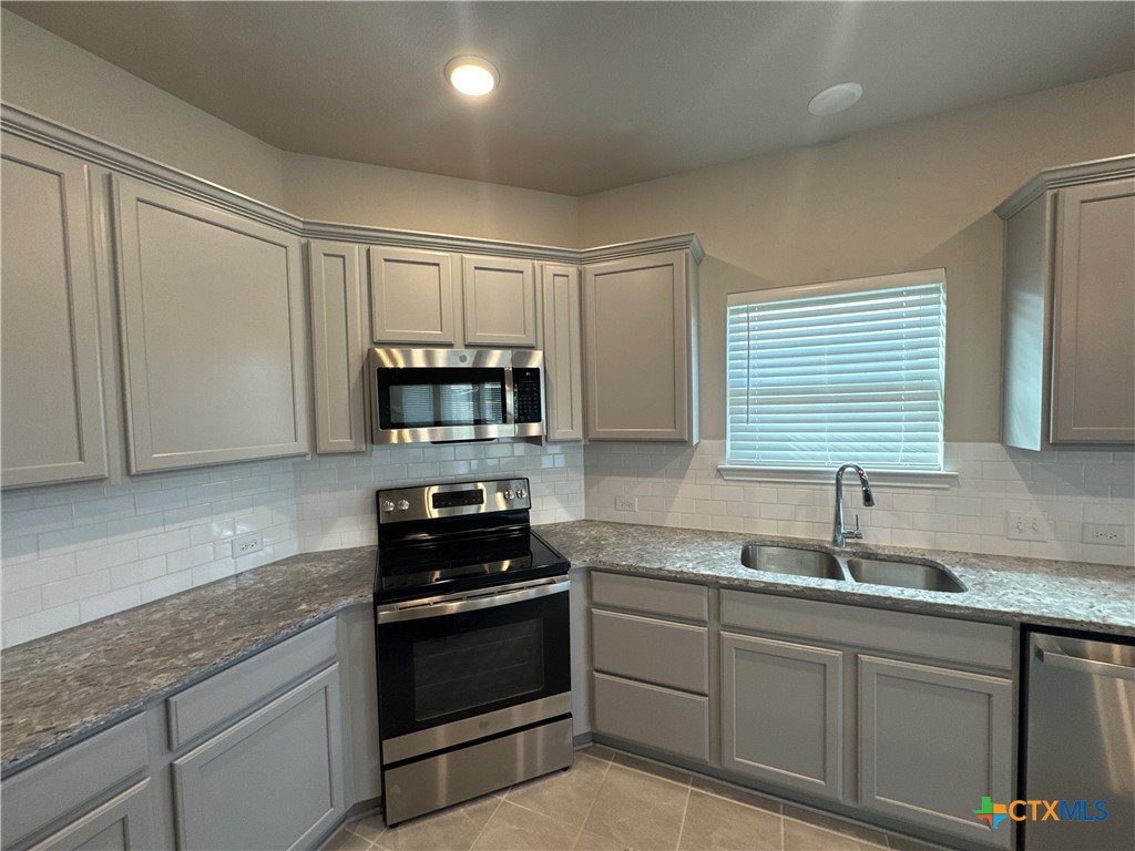 2214 Wasabi Road Temple, TX 76501 - Photo 8 of 26 a kitchen with granite countertop a sink stainless steel appliances and cabinets