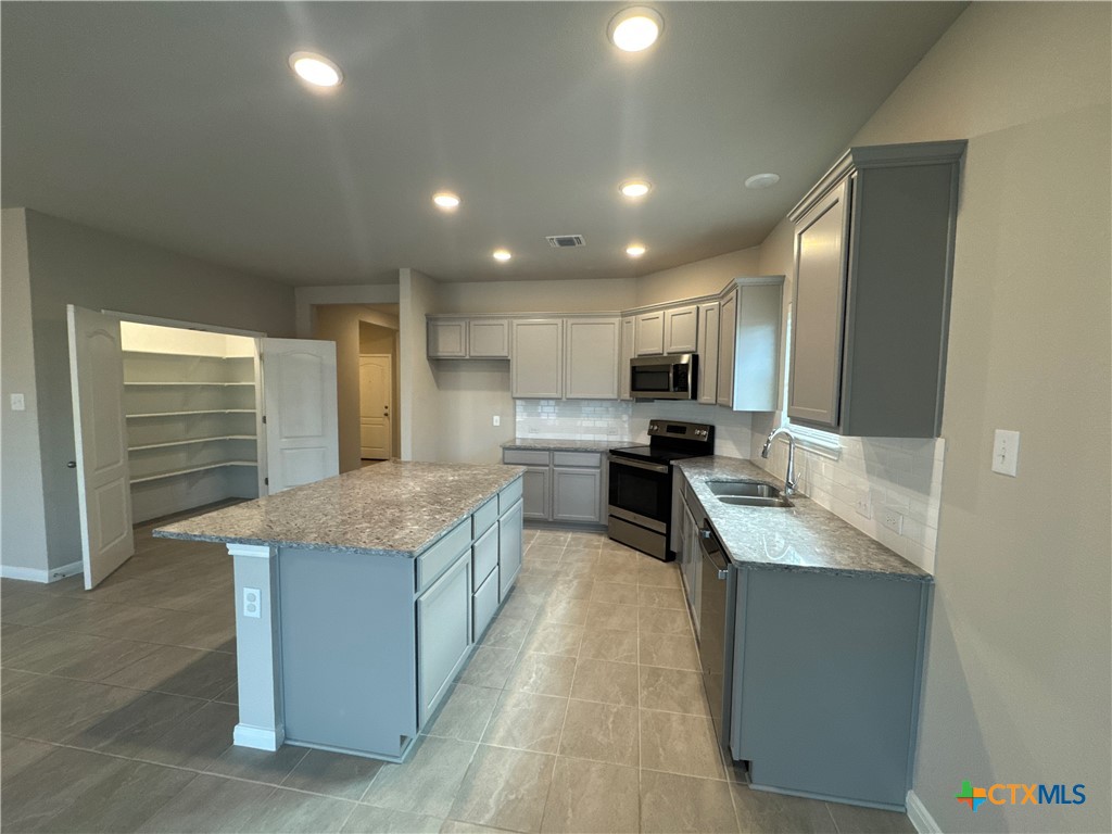 2214 Wasabi Road Temple, TX 76501 - Photo 9 of 26 a large kitchen with kitchen island a sink stainless steel appliances and cabinets