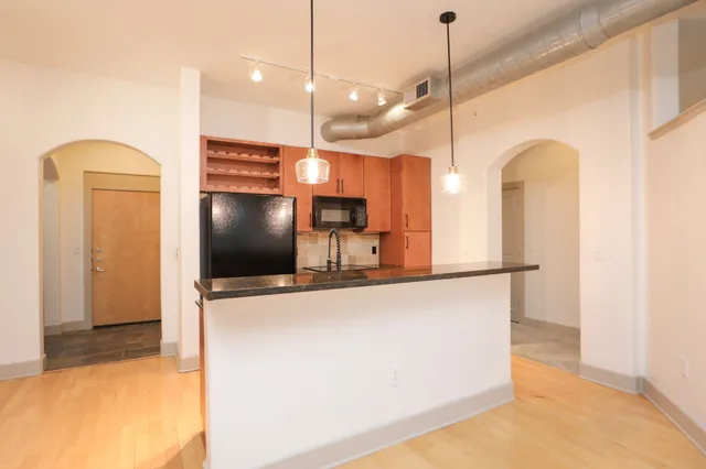 a kitchen with stainless steel appliances granite countertop a refrigerator and a stove