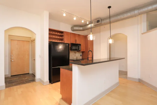 a kitchen with stainless steel appliances granite countertop a sink a stove and a refrigerator