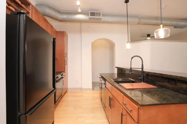 a kitchen with stainless steel appliances granite countertop a sink a stove and a refrigerator