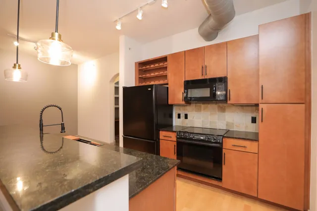 a kitchen with stainless steel appliances granite countertop a refrigerator and a stove top oven