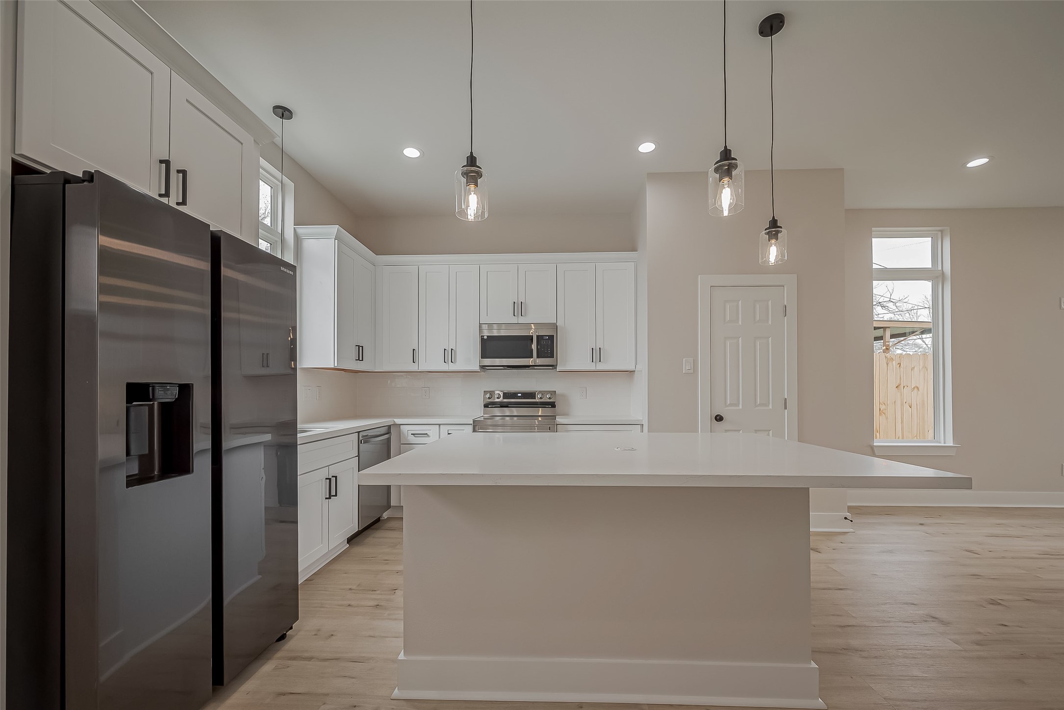 918 St Clair Street, Unit B Houston, TX 77088 - Photo 13 of 35 a kitchen with stainless steel appliances kitchen island granite countertop a refrigerator a sink a stove and oven with wooden floor