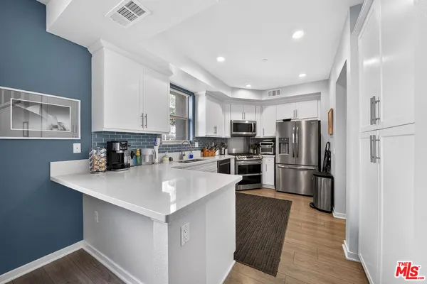 a kitchen with white cabinets and stainless steel appliances