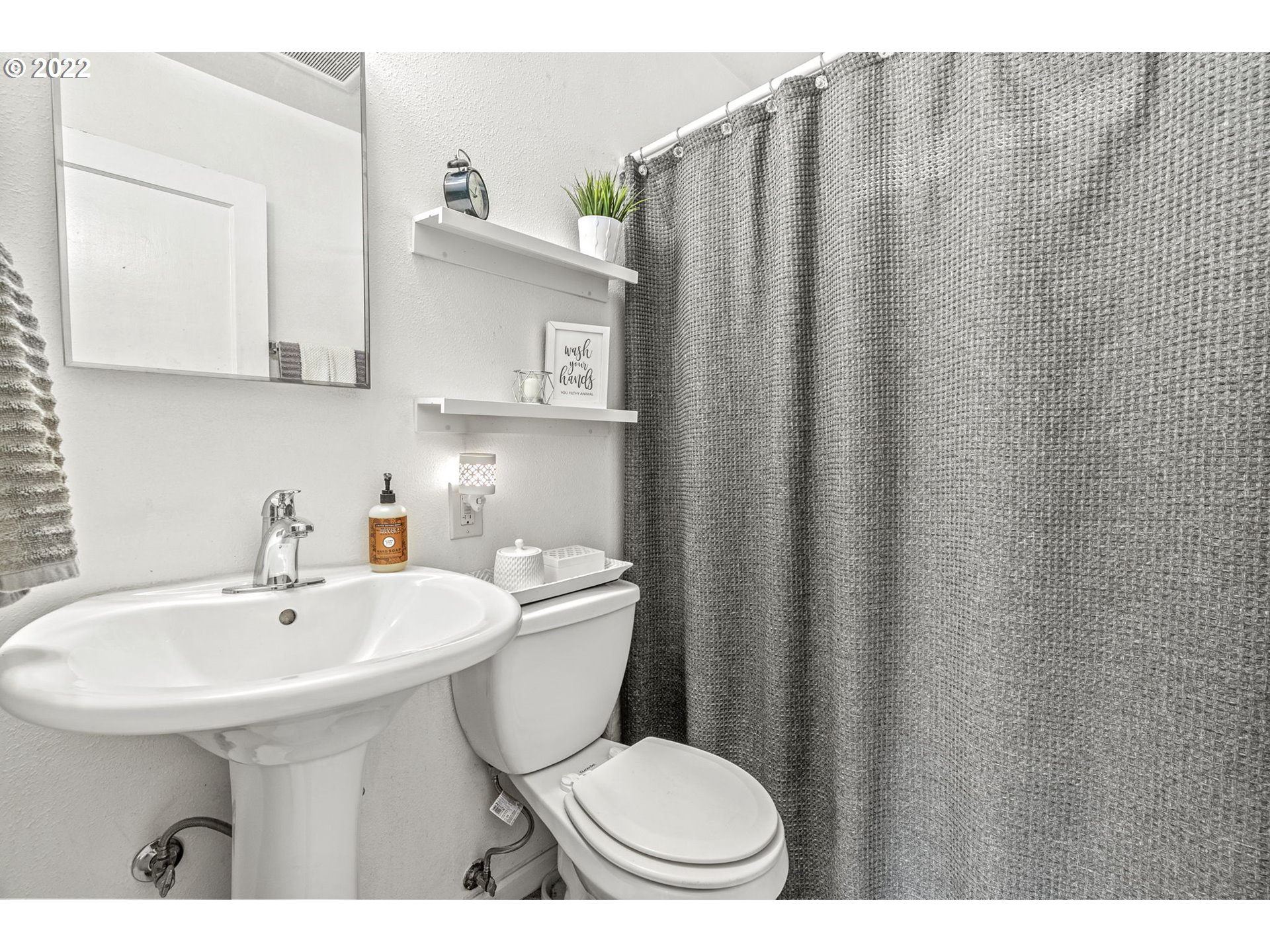 1057 17th Avenue Longview, WA 98632 - Photo 12 of 30 a bathroom with a sink a toilet and mirror