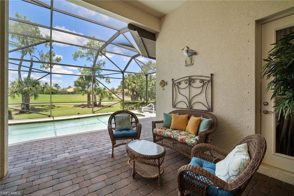 6476 Caldecott Drive Naples, FL 34113 - Photo 22 of 27 a living room with furniture and a floor to ceiling window