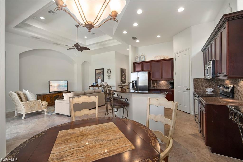 6476 Caldecott Drive Naples, FL 34113 - Photo 10 of 27 a living room with lots of furniture and kitchen view