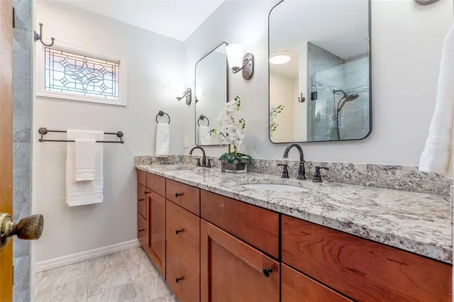 a bathroom with a granite countertop sink and a mirror