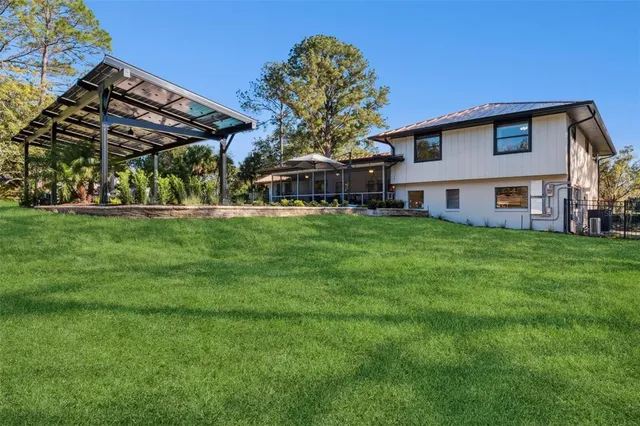 a view of a house with pool and chairs