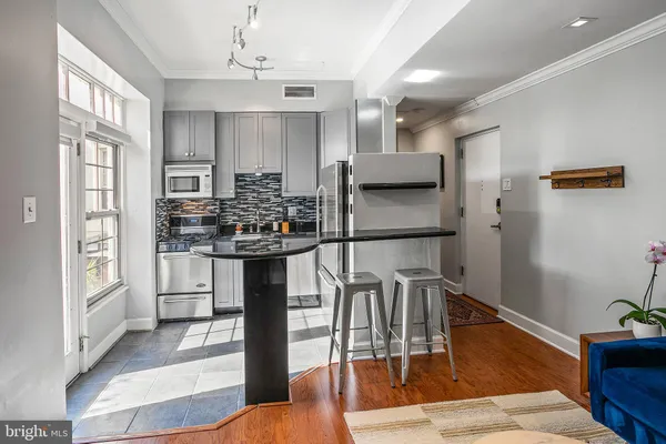a kitchen with stainless steel appliances kitchen island granite countertop a refrigerator and microwave