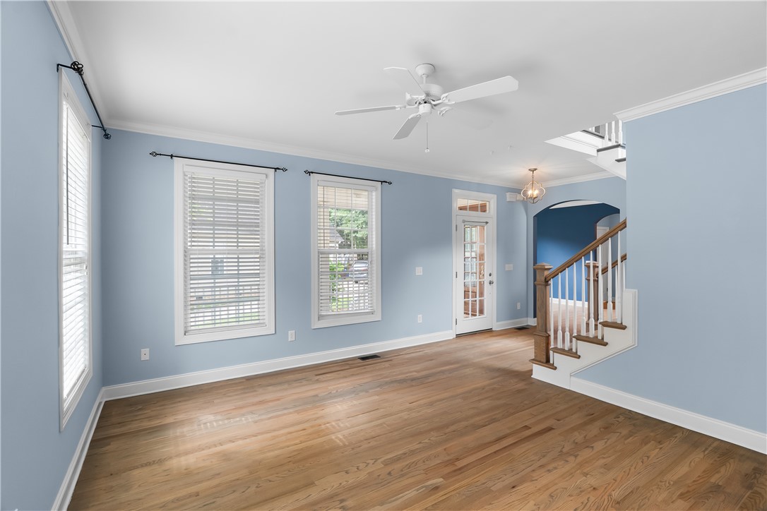 206 Village Way Pendleton, SC 29670 - Photo 5 of 46 Hardwood flooring extends throughout this light-filled living area, complete with a glass-paneled exterior door and a welcoming staircase.
