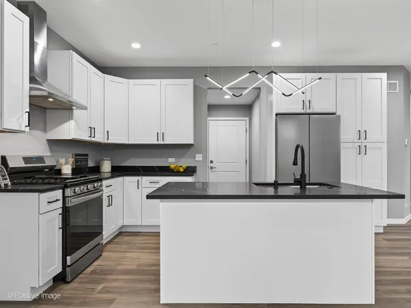 a kitchen with stainless steel appliances granite countertop a refrigerator and a stove